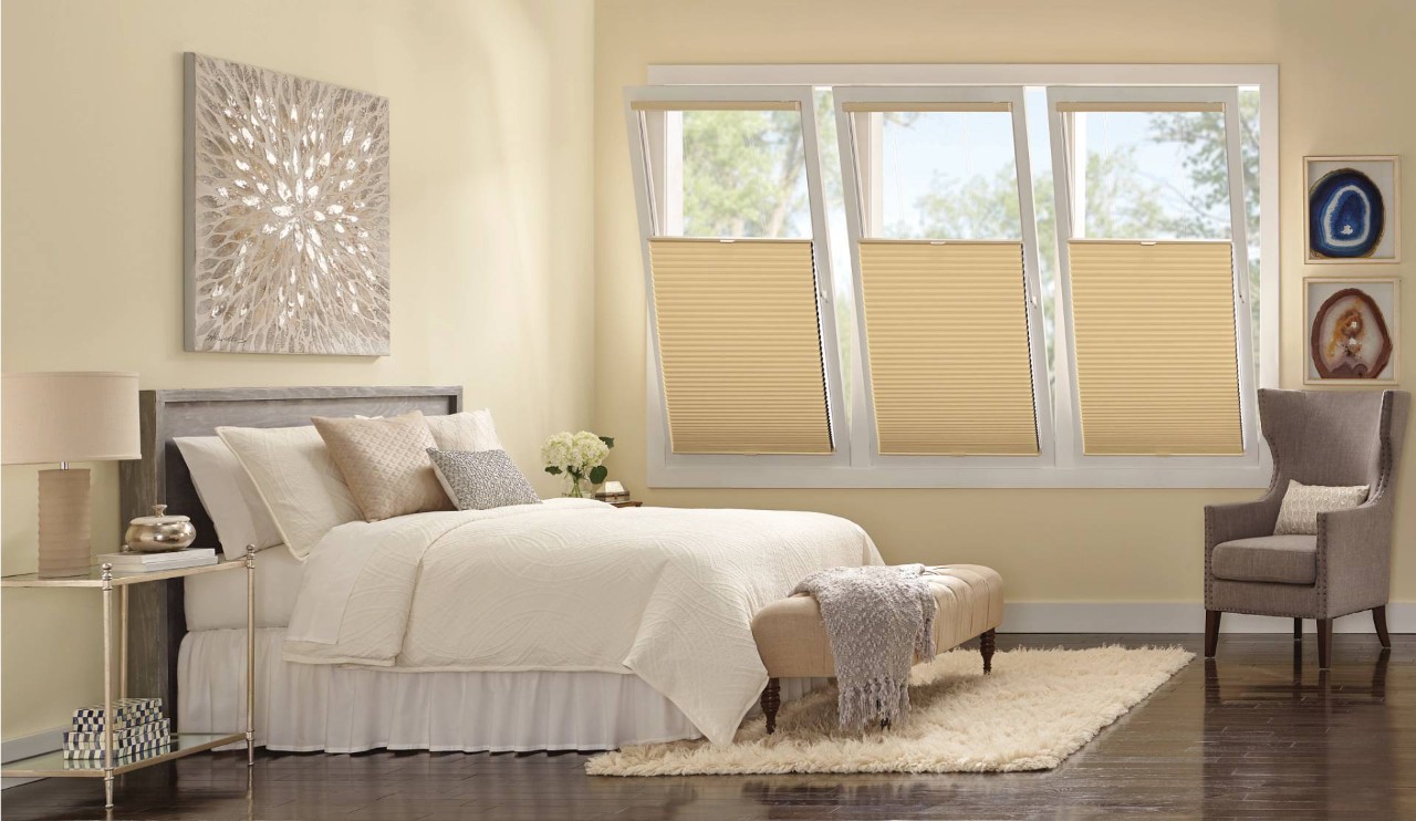 Simply decorated bedroom with three open windows, all outfitted with Hunter Douglas Duette® Cellular Shades at North Idaho Blinds, Shades, & Shutters near Hayden, ID