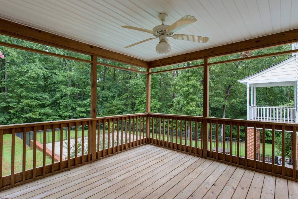 Custom exterior shades on a patio with a ceiling fan in a woodland backyard near Hayden, ID